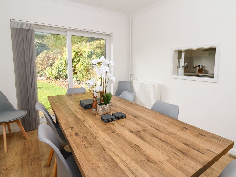 A dining room with a table and chairs at Tymelyn in Aberystwyth