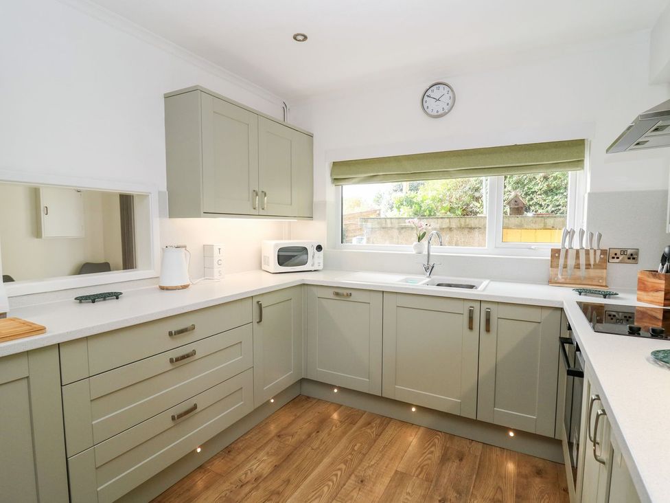 A kitchen with cabinets and a microwave at Tymelyn in Aberystwyth