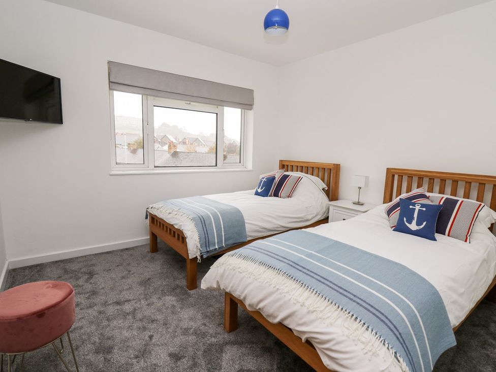 A bedroom with twin beds and a television at Tymelyn in Aberystwyth