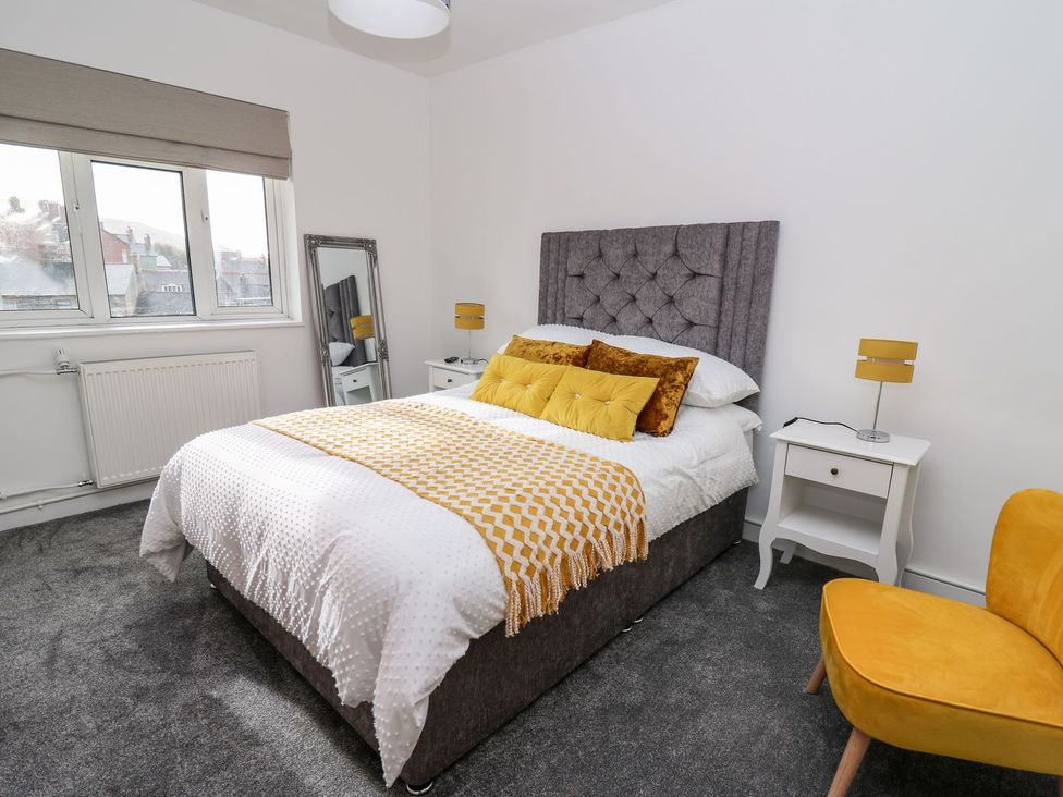A bedroom with a bed and nightstand at Tymelyn in Aberystwyth