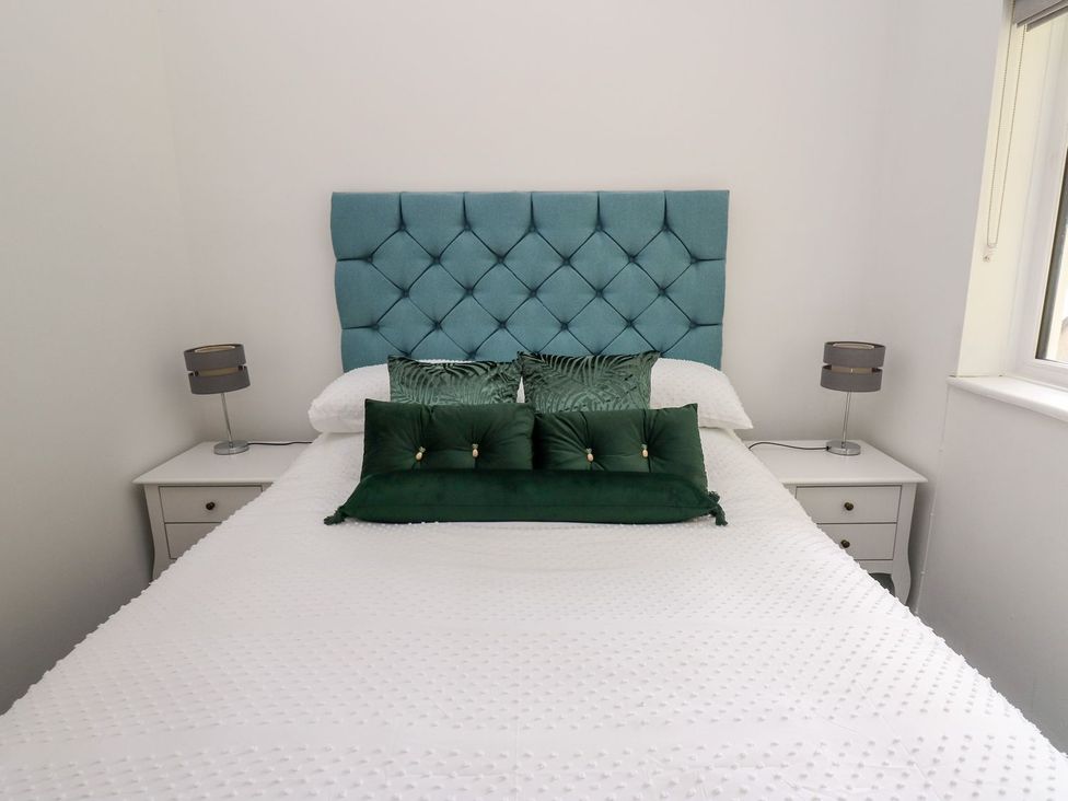 A bedroom with a bed and bedside tables at Tymelyn in Aberystwyth
