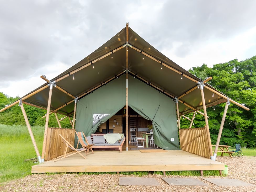 A glamping tent with seating and dining area at Badger - Luxury Glamping Retreat in Battle