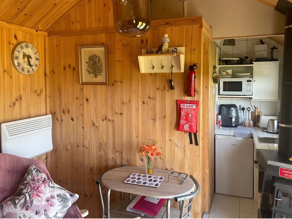 A kitchen with wooden walls and appliances at Tylands in Camelford