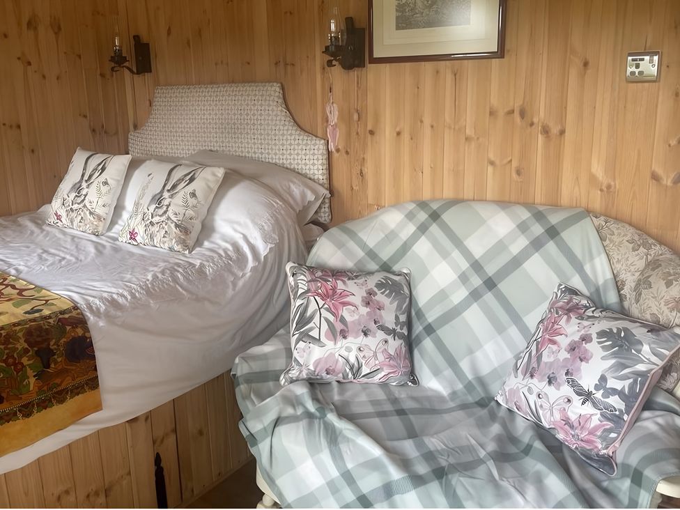 A bedroom with a bed and sofa at Tylands in Camelford