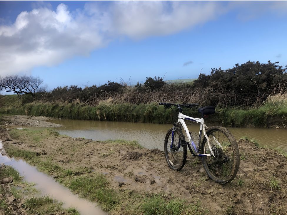 A mountain bike near a muddy path and water at Tylands in Camelford