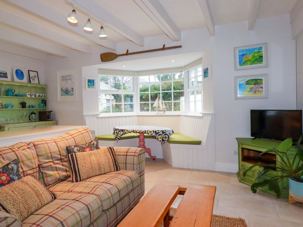 A living room with a sofa and dining area at Cubbs Corner in Goonbell near St Agnes