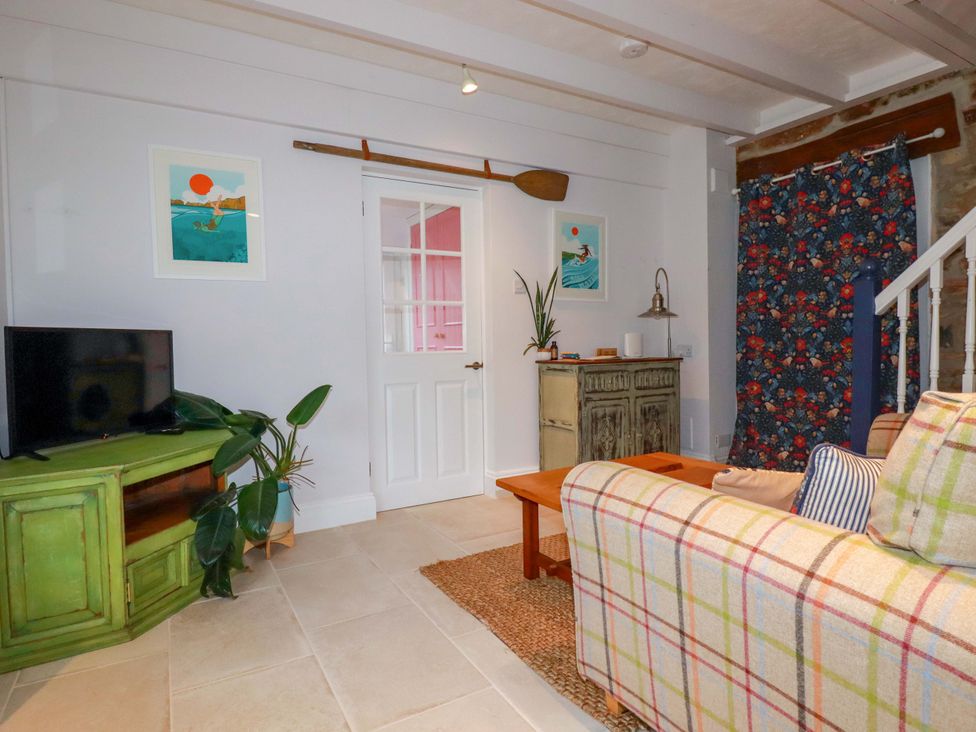 A living room with a television and a sofa at Cubbs Corner in Goonbell near St Agnes