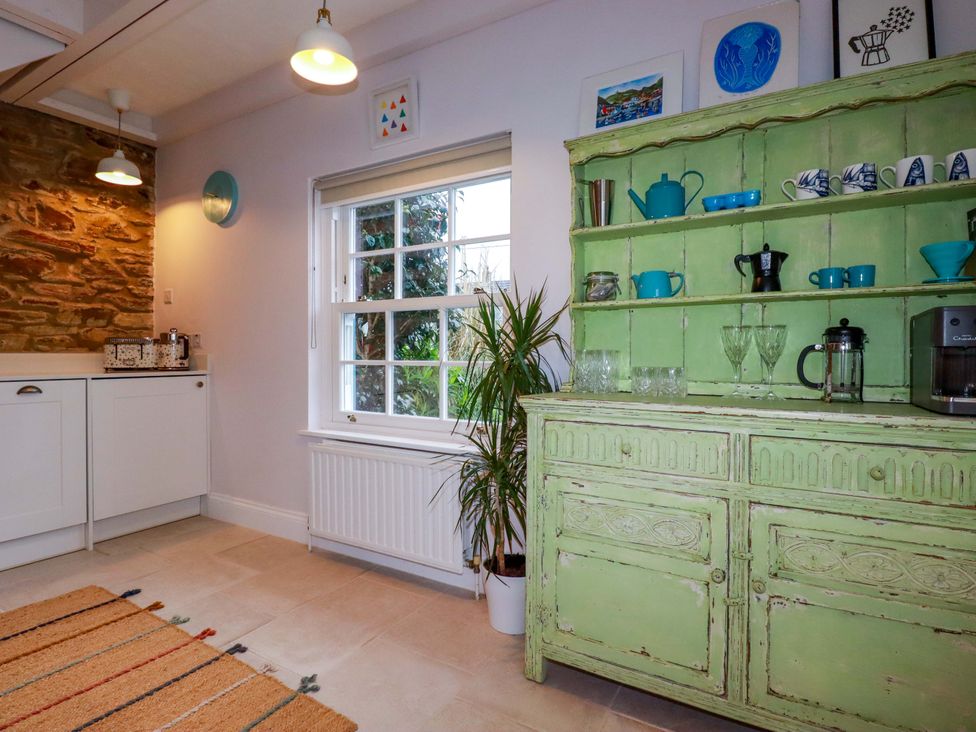 A kitchen with a green dresser and window at Cubbs Corner Goonbell near St Agnes
