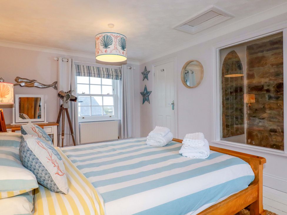 A bedroom with a bed and decorative features at Cubbs Corner in Goonbell near St Agnes