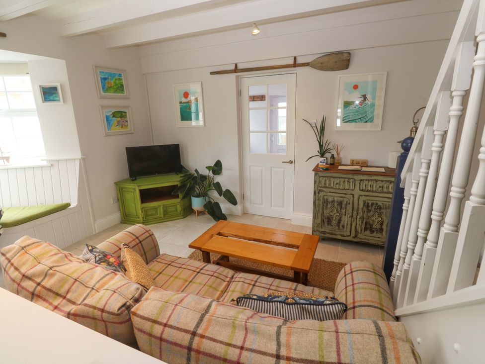 A living room with a sofa and coffee table at Cubs Corner in St Agnes