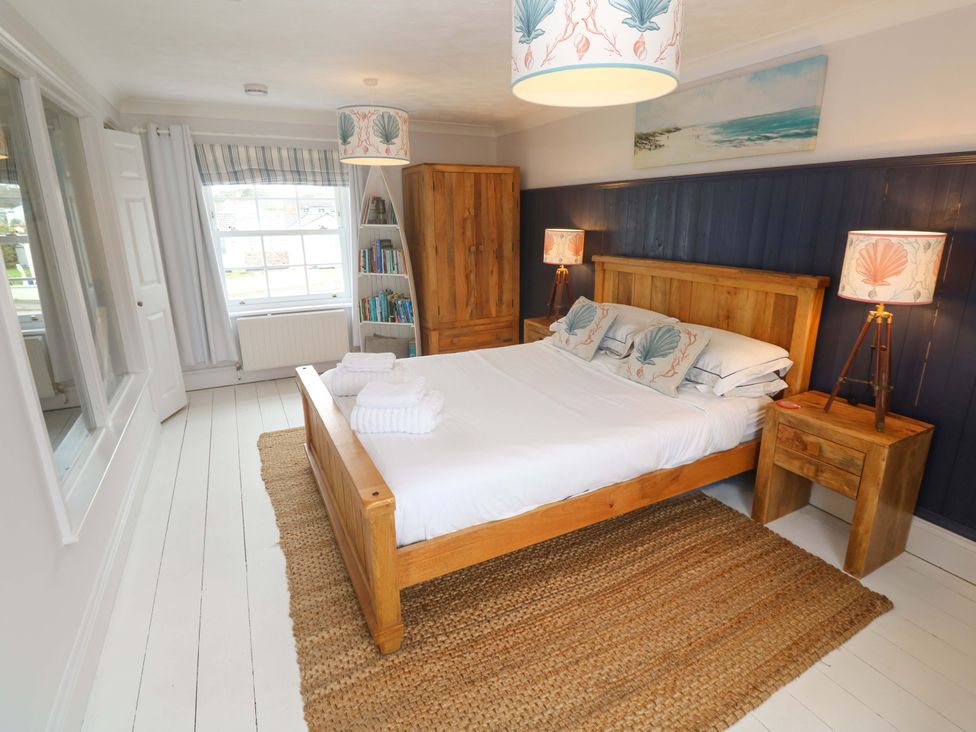 A bedroom with a bed and a bookshelf at Cubs Corner in St Agnes