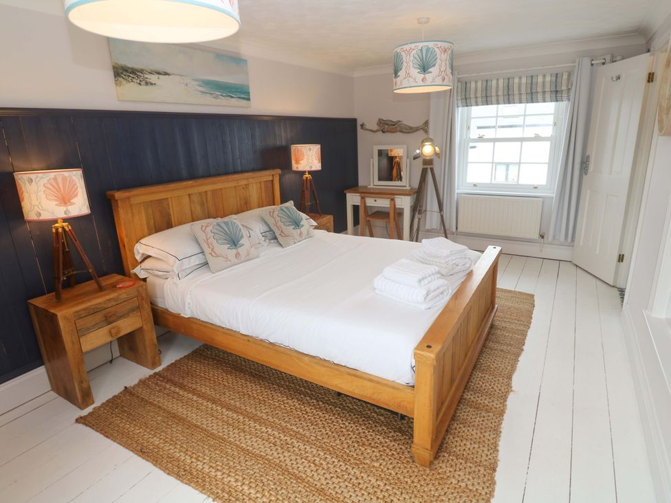 A bedroom with a bed and bedside tables at Cubs Corner in St Agnes