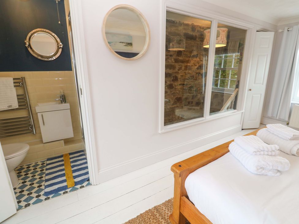 A bedroom with a bed and bathroom visible at Cubs Corner in St Agnes