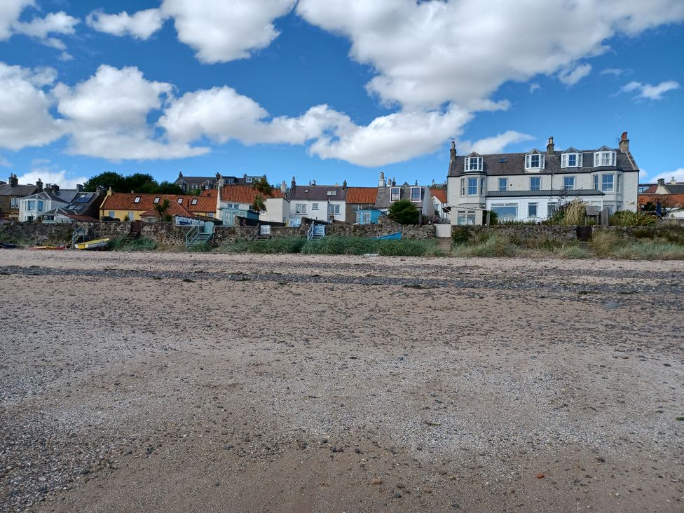 A beach with houses in the background at Beach Haven 116 Leven