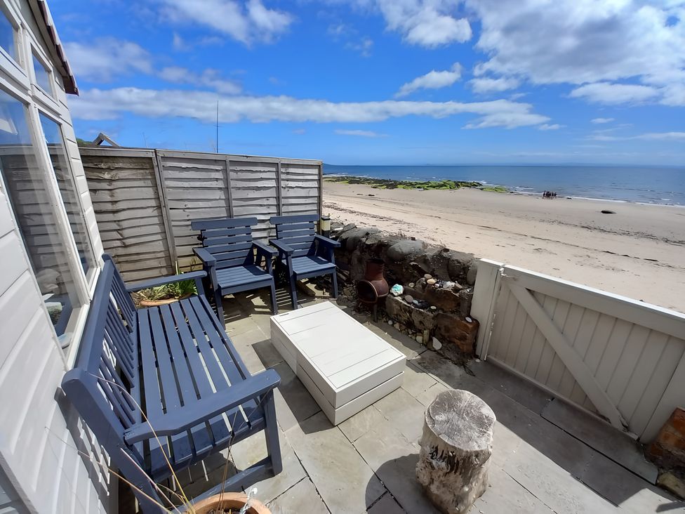 An outdoor area with deck chairs and a table at Beach Haven 116 Leven