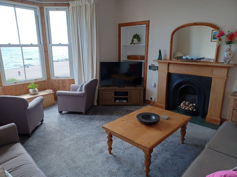 A living room with a television and a fireplace at Beach Haven 116 in Leven