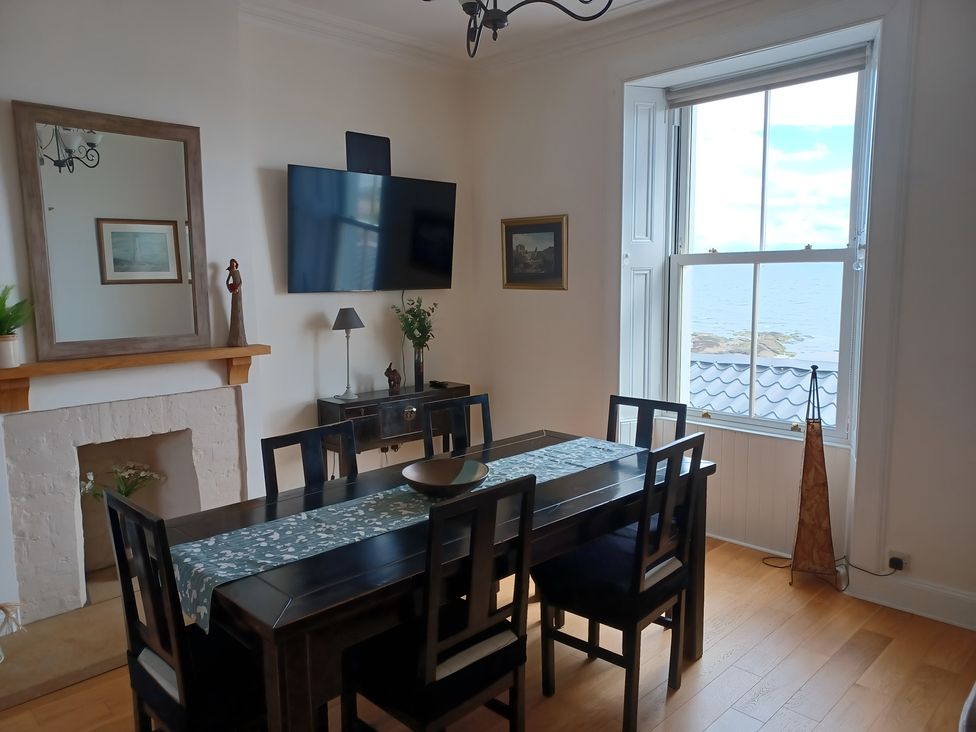 A dining room with a table and chairs at Beach Haven 116 Leven