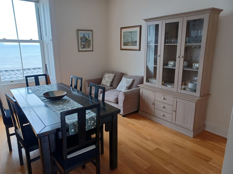 A dining room with a table and chairs at Beach Haven 116 Leven
