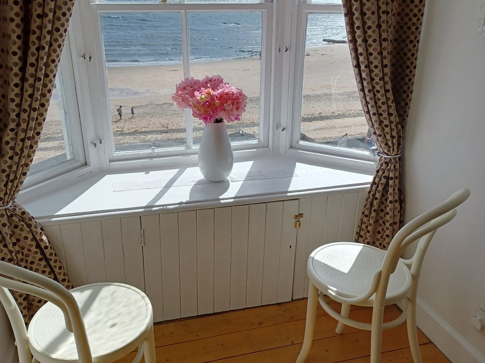 A dining room with a window facing the beach at Beach Haven 116 in Leven