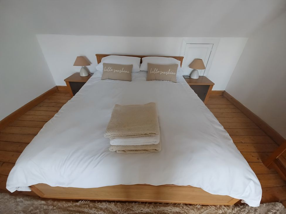 A bedroom with a bed and bedside tables at Beach Haven 116 in Leven