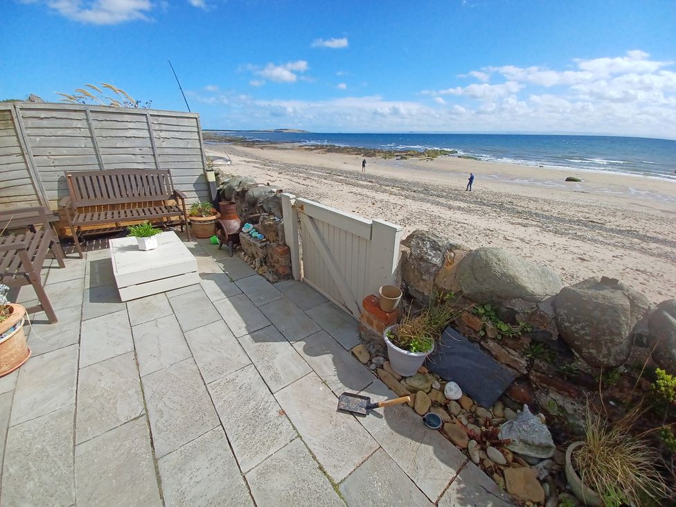 An outdoor area with a beach view and seating at Beach Haven 116 in Leven