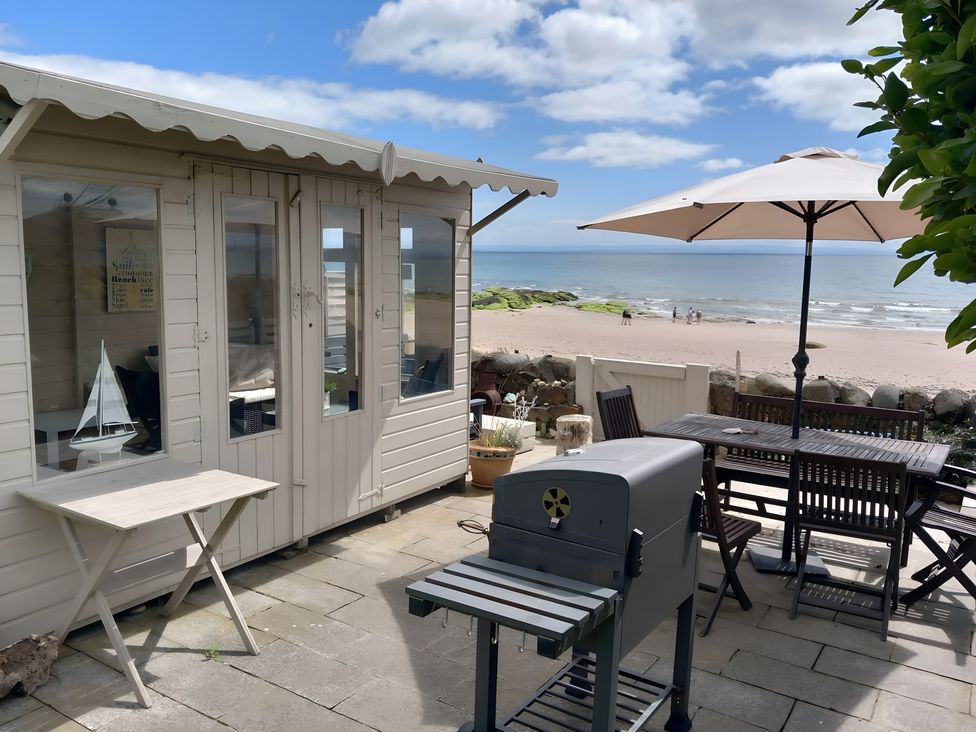 An outdoor area with a barbecue and seating at Beach Haven 116 in Leven