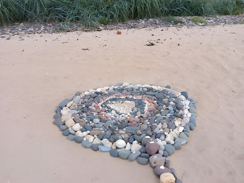 A circular arrangement of pebbles on sand at Beach Haven 116 in Leven