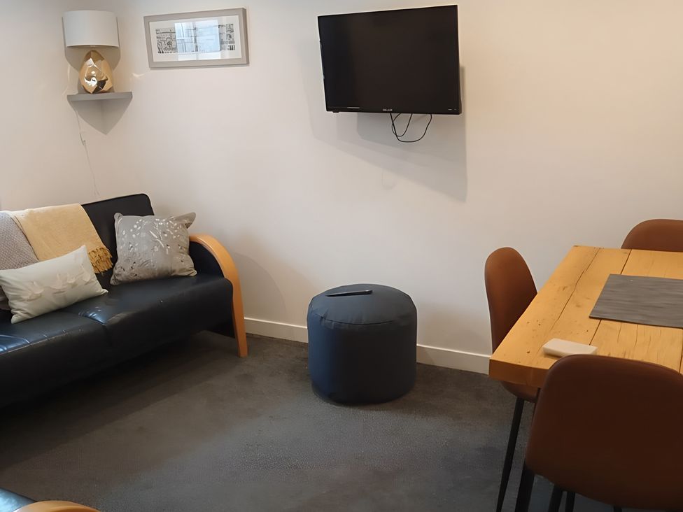 A living room with a couch and dining table at 14 Largo Road in Leven