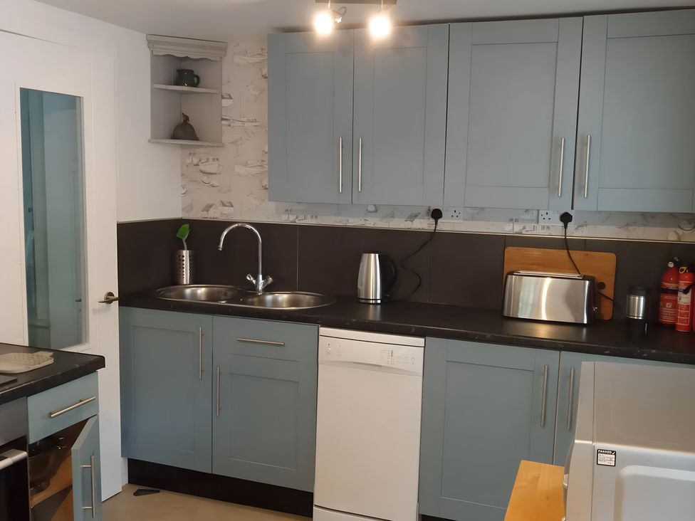 A kitchen with cabinets, sink, kettle, toaster, and dishwasher at 14 Largo Road Leven