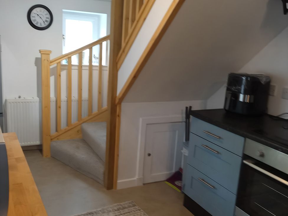 A kitchen with a staircase and kitchen appliances at 14 Largo Road Leven