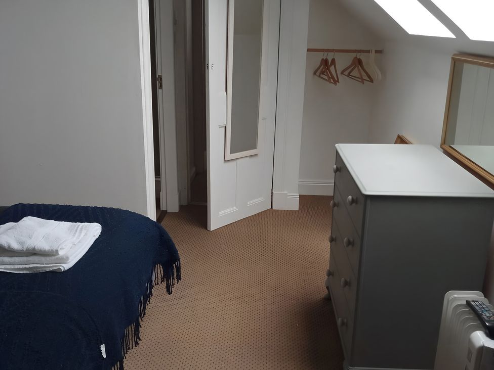 A bedroom with a bed towels and a dresser at 14 Largo Road Leven