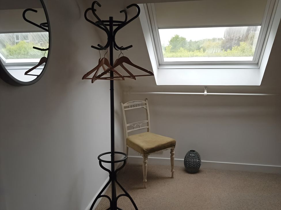 A coat rack and chair in a room at 14 Largo Road, Leven
