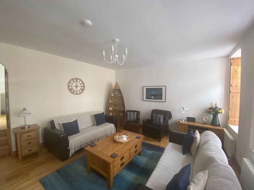 A living room with a sofa and coffee table at Coastal Cottage in Anstruther