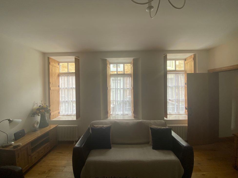 A living room with windows and a sofa at Coastal Cottage in Anstruther