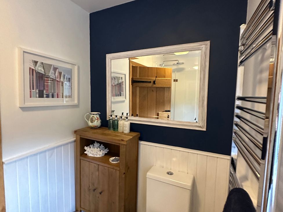 A bathroom with a toilet and mirror at Coastal Cottage in Anstruther