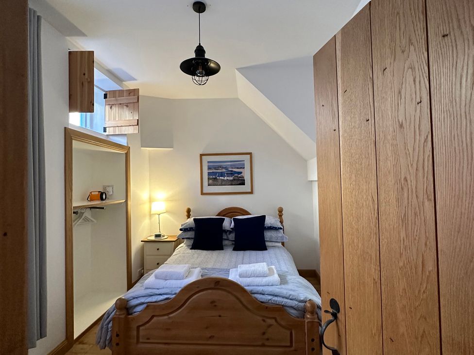 A bedroom with a bed and lamp at Coastal Cottage Anstruther