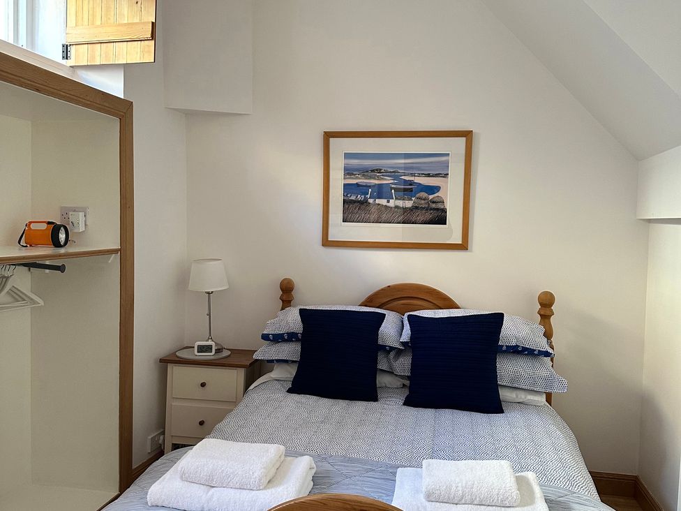 A bedroom with a bed and wall art at Coastal Cottage Anstruther