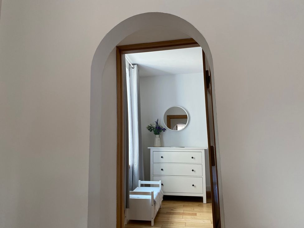 A bedroom with a dresser and mirror at Coastal Cottage in Anstruther