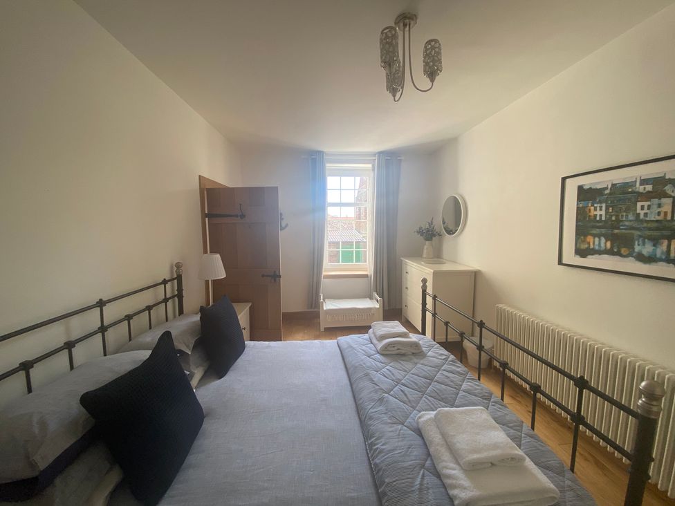 A bedroom with a bed and dresser at Coastal Cottage Anstruther