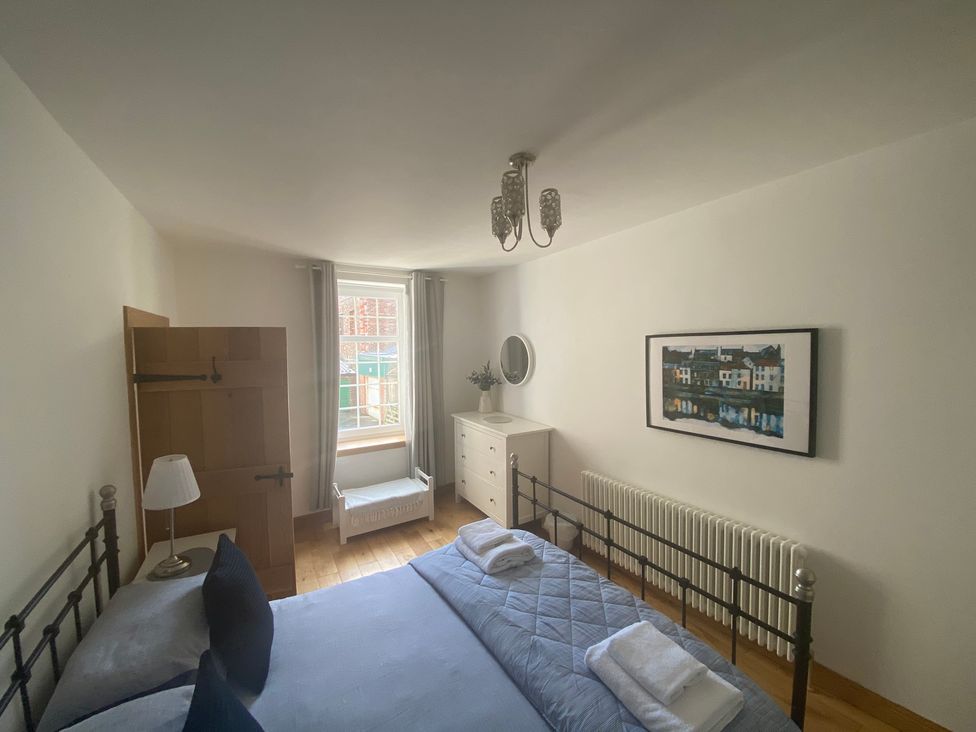 A bedroom with a bed and wardrobe at Coastal Cottage Anstruther