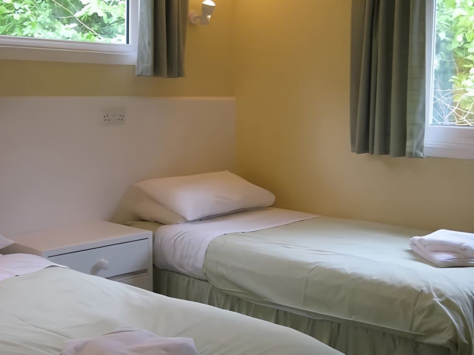 A bedroom with two beds and a window at Satchwell Chalet in Inverness