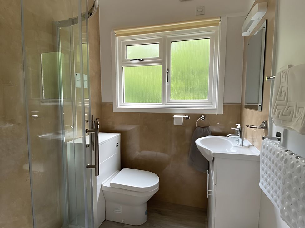 A bathroom with a shower, toilet, and sink at Satchwell Chalet in Inverness