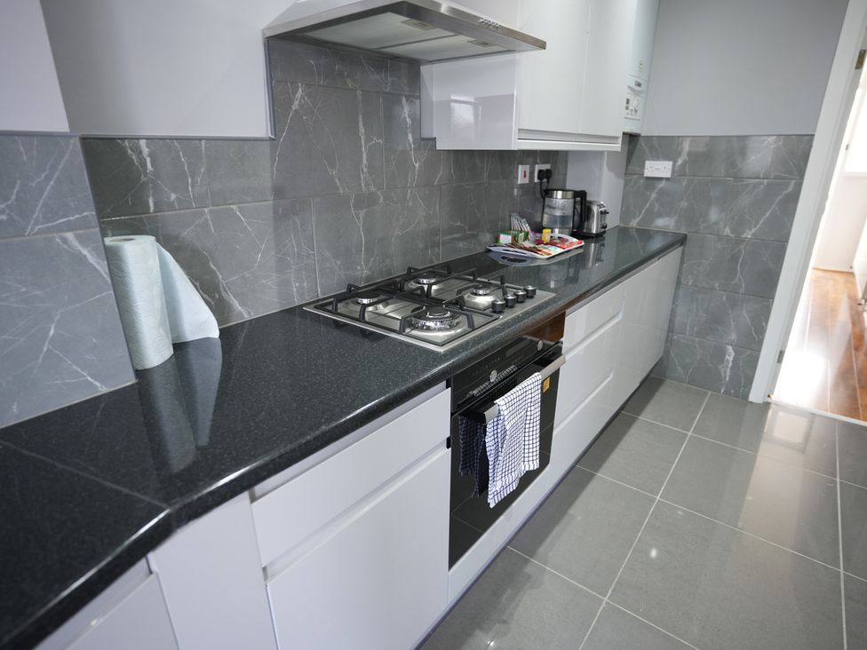 A kitchen with a gas stove and countertop at Westwick Gardens Retreat in Hounslow