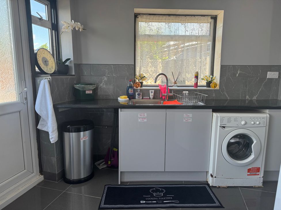 A kitchen with sink and washing machine at Westwick Gardens Retreat in Hounslow
