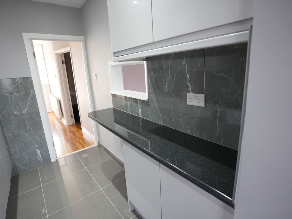 A kitchen with a countertop and shelf at Westwick Gardens Retreat in Hounslow