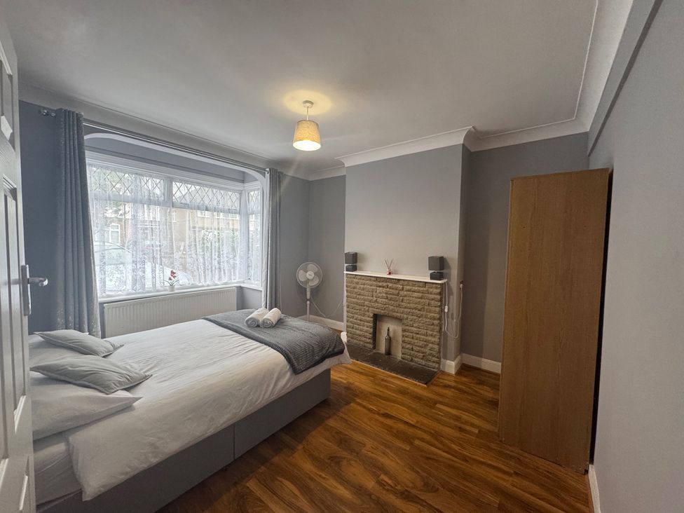 A bedroom with a bed and wardrobe at Westwick Gardens Retreat in Hounslow