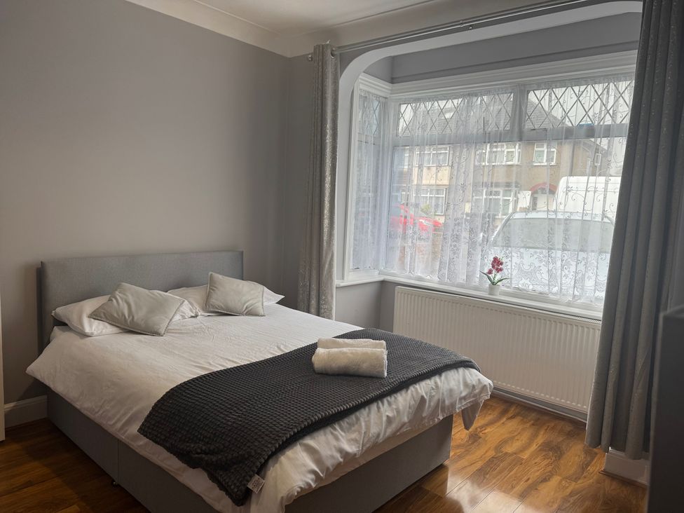 A bedroom with a bed and window at Westwick Gardens Retreat Hounslow