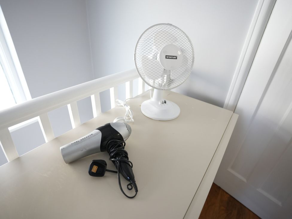 A hair dryer and small fan on a table at Westwick Gardens Retreat in Hounslow