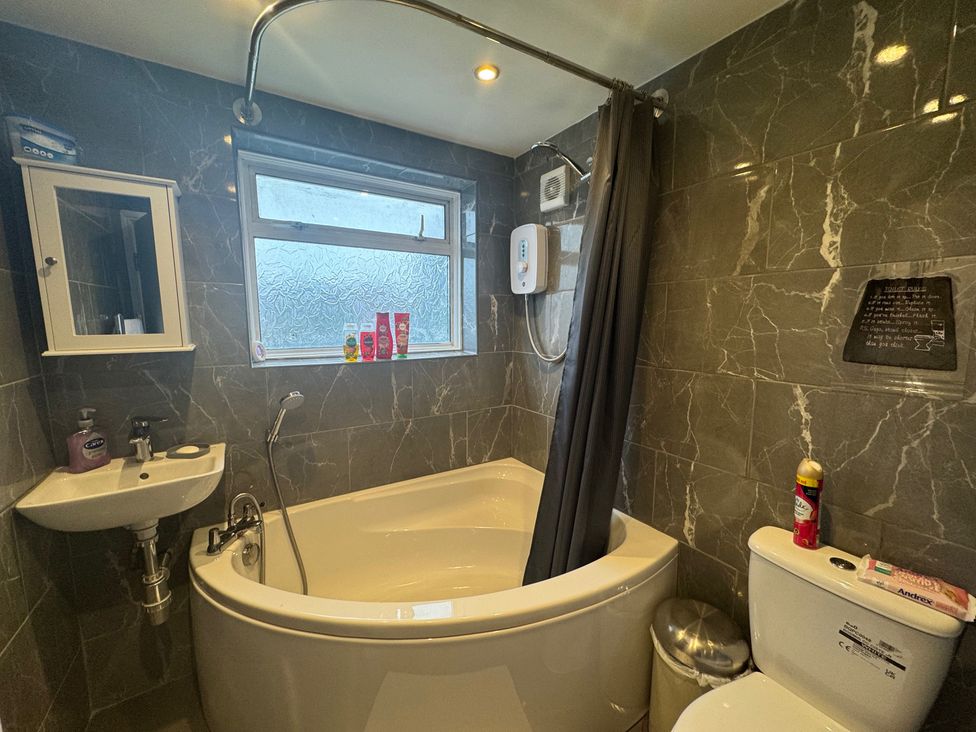 A bathroom with a bath tub and shower at Westwick Gardens Retreat in Hounslow