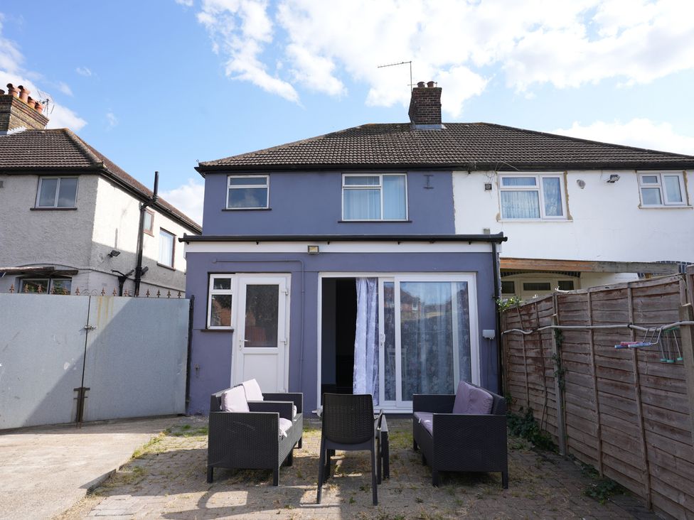 An outdoor area with chairs and a view of a house at Westwick Gardens Retreat Hounslow